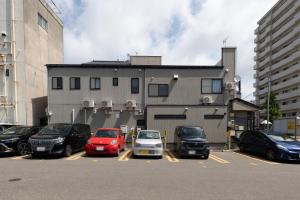 parking z samochodami zaparkowanymi przed budynkiem w obiekcie higashibori five w mieście Niigata