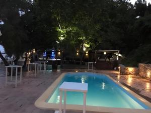 a pool at night with a table and chairs at Fanis Rooms in Kokkino Nero