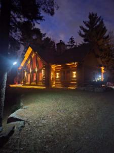 une maison éclairée la nuit avec des lumières dans l'établissement Family fun private outdoor hot tub, à Mille-Isles