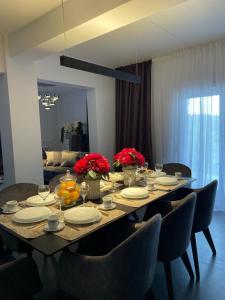 a dining room table with chairs and plates and flowers at Family friendly house with a swimming pool Imotski, Zagora - 24581 in Imotski