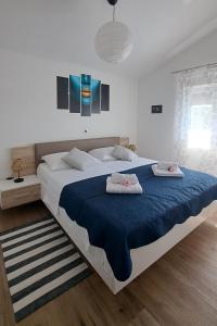 a bedroom with a large bed with two pillows on it at Family friendly house with a swimming pool Maslenica, Novigrad - 24641 in Maslenica