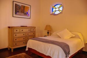 una camera con letto, cassettiera e vetrata colorata di Live in the historical downtown! a San Miguel de Allende