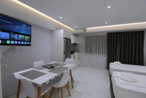 a room with a table and chairs and a tv at Dream Seaview Apartment INI in Íshulli i Tetranisit