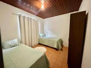 a small room with two beds and a window at Casa em Condomínio no Centro de Ponta Porã in Ponta Porã