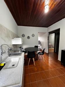 a kitchen with a sink and a table and chairs at Casa em Condomínio no Centro de Ponta Porã in Ponta Porã