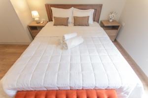 a large white bed with two towels on it at Luxurious 2 Bed Apt W Gym & Pool In Villa Morra in Asuncion +29 photos