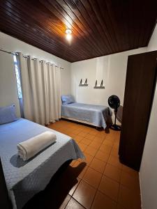 a bedroom with two beds and a fan in it at Casa em Condomínio no Centro de Ponta Porã in Ponta Porã