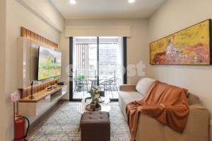 a living room with a couch and a tv at Luxurious 2 Bed Apt W Gym & Pool In Villa Morra in Asuncion