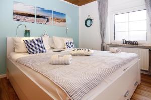 a bedroom with a large bed with two pillows on it at Reihenhaus Land and Sea in Büsum in Büsum