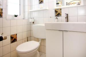 a white bathroom with a toilet and a sink at Reihenhaus Land and Sea in Büsum in Büsum +15 photos