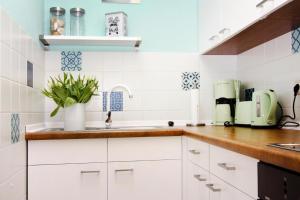 a kitchen with white cabinets and a sink at Reihenhaus Land and Sea in Büsum in Büsum