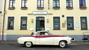 a red and white car parked in front of a building at Romantisches Hotel Zur Traube Schwerin in Schwerin