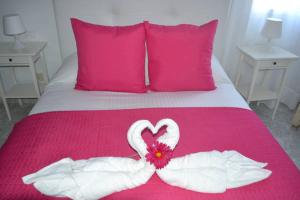 Una cama con un corazón hecho de toallas en Elena Beach House Lanzarote, en Playa Honda