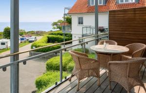 a balcony with a table and chairs and the ocean at Amazing Apartment In Gudhjem With Wifi in Gudhjem +16 photos