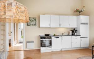 a kitchen with white cabinets and a stove top oven at 2 Bedroom Gorgeous Home In Gudhjem in Gudhjem
