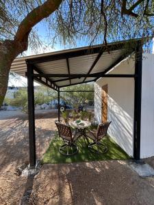 a patio with a table and two chairs under a roof at Casita Palo Verde in San José del Cabo +5 photos