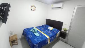 a small bedroom with a blue bed in a room at Villa Palmeras Hotel Campestre in Espinal