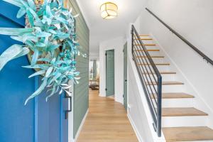 Un pasillo con escaleras y una pared azul con una gran planta azul. en Emerald Horizon 104 Azalea Ct, en Clarksville