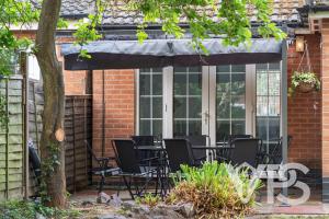 a patio with chairs and an awning on a house at Contractors Family Near Hospital in Leicester