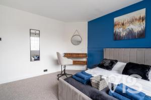 a bedroom with blue walls and a bed and a chair at Contractors Family Near Hospital in Leicester