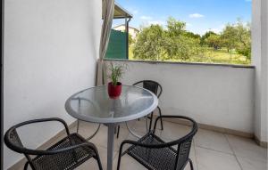 a table and chairs on a balcony with a window at Nice Apartment In Lovrecica With Wifi in Lovrečica