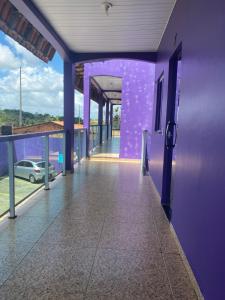 a purple building with a hallway with a car on it at Pousada hotel trevo do Atalaia in Salinópolis