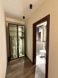 a bathroom with a toilet and a glass door at شقة فندقية أبراج زد الشيخ زايد القاهرة Zed Towers in Sheikh Zayed +7 photos