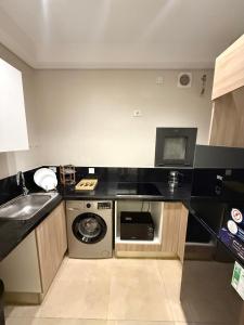 a small kitchen with a sink and a washing machine at شقة فندقية أبراج زد الشيخ زايد القاهرة Zed Towers in Sheikh Zayed