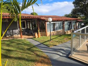 a house with a palm tree in the yard at Quinta das Palmeiras Area 2 in Montes Claros