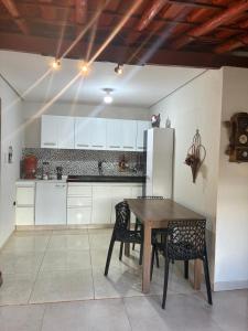 a kitchen with a wooden table and a refrigerator at Quinta das Palmeiras Area 2 in Montes Claros
