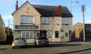 two cars parked in front of a building at Gilesgate Moor Hotel in Durham