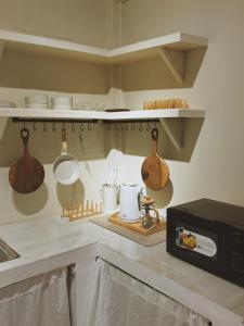 a kitchen with a counter with utensils and a microwave at Fika Siargao - Cozy Island Home in General Luna in General Luna
