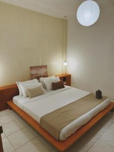 a bedroom with a large bed with white sheets at Fika Siargao - Cozy Island Home in General Luna in General Luna