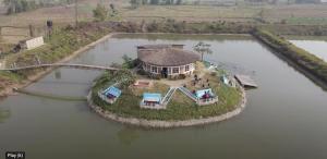 an aerial view of a house on an island in the water at Fish O Farm Guest House in Jhawāni