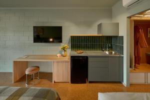 a kitchen with a counter with a sink and a table at River Drive Motel in Venus Bay