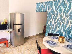 a kitchen with a table and a refrigerator at Nuevo Depa Turquesa chic y súper cómodo in Ciudad Victoria +5 photos