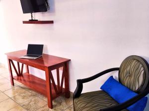a desk with a chair next to a table with a laptop at Nuevo Depa Turquesa chic y súper cómodo in Ciudad Victoria