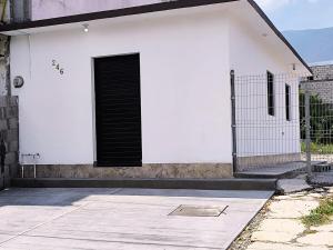 a black door on a white building with a gate at Nuevo Depa Turquesa chic y súper cómodo in Ciudad Victoria