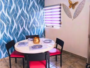a dining room with a table and chairs with butterflies on the wall at Nuevo Depa Turquesa chic y súper cómodo in Ciudad Victoria