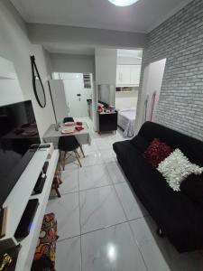 a living room with a black couch and a table at Ap914 Temporada Santos in Santos