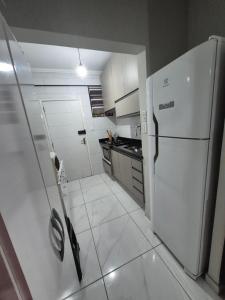 a kitchen with a white refrigerator and a white tile floor at Ap914 Temporada Santos in Santos +36 photos
