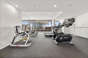 a gym with several treadmills and cardio machines at Belle Escapes Harbour Lights Waterfront Apartment 501-502 in Cairns