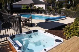 ein Swimmingpool mit Whirlpool neben einem Swimmingpool in der Unterkunft Blue Penguin - Russell Cottages Collection 2-4 Bedroom in Russell