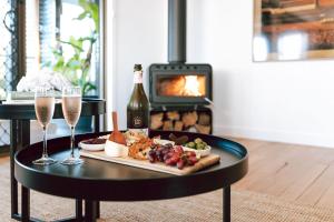 a tray of food and wine on a table with a fireplace at Omaru Beach House in Scamander