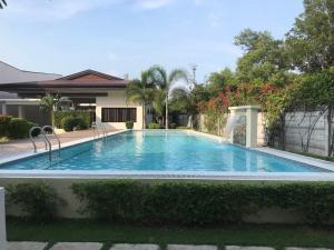 a swimming pool in front of a house at Almond Drive Talisay in Tangke