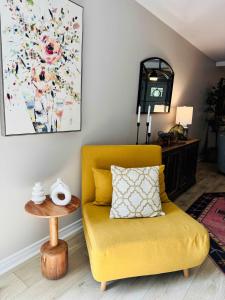 un divano giallo in un soggiorno con un tavolino di Charming & Luxe Cottage 3 BR 2 BA a Nederland