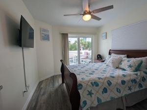 Un dormitorio con una cama con ventilador de techo. en Oceanfront 2br2b, Ocean Views, Heated Pool, Spa, en Cabo Cañaveral