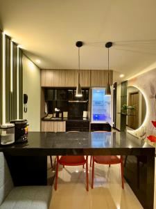 a kitchen with a large black table and red chairs at Dpto Home Office - Smart - Piscina - Cowork - Gym in Santa Cruz de la Sierra