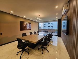 a conference room with a large wooden table and chairs at Dpto Home Office - Smart - Piscina - Cowork - Gym in Santa Cruz de la Sierra +35 photos