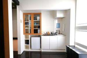 una cucina con mobili bianchi e un frigorifero bianco di Uji-Ichibanyado-Nigauri a Ogurachō
